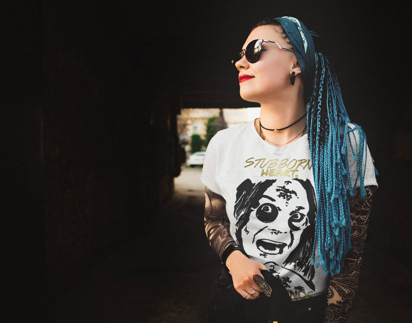 Metalhead woman with blue dreadlocks wearing a white tee from the LEGENDS COLLECTION: by STUBBORN HEART Apparel of the Rock god Ozzy Osbourne from Black Sabbath
